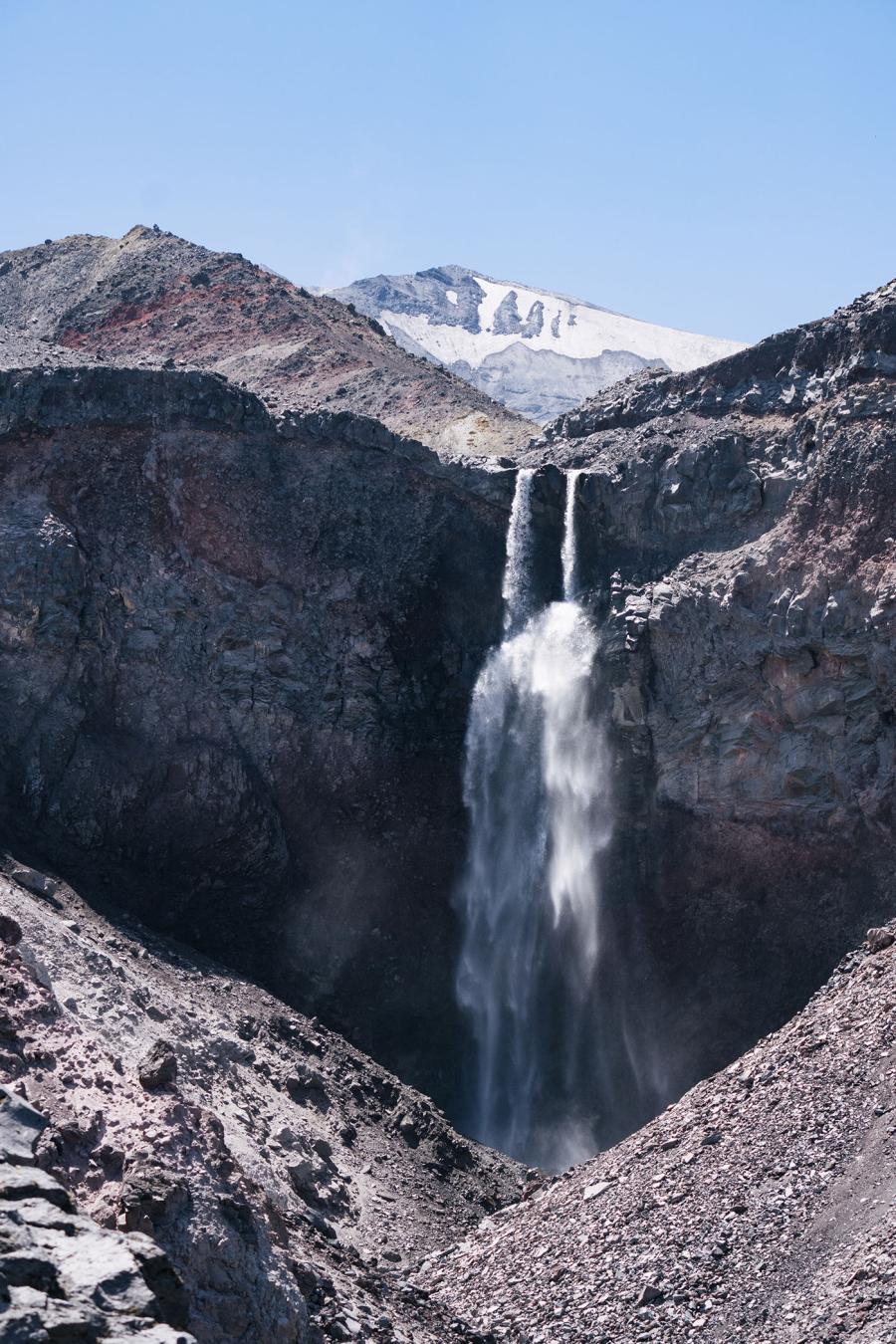 A large waterfall in a rocky, mountainous area